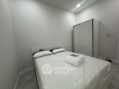 Cozy minimalist bedroom with modern wardrobe and comfortable bed in a serene setting.