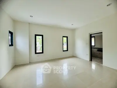 Spacious empty room with large windows and tiled flooring