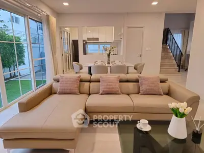 Spacious modern living room with elegant beige sectional sofa and open kitchen layout