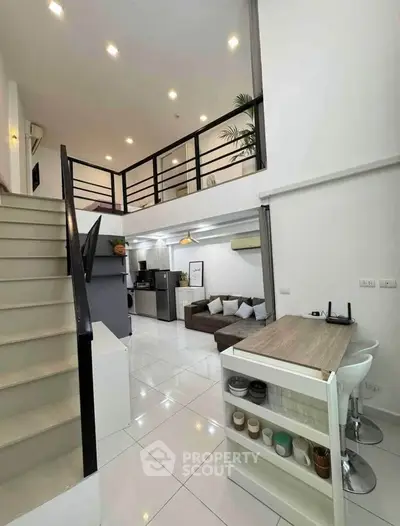 Modern loft-style living room with open kitchen and stylish staircase