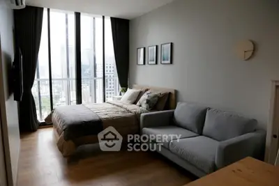 Modern bedroom with city view, featuring a cozy bed and stylish sofa, perfect for urban living.