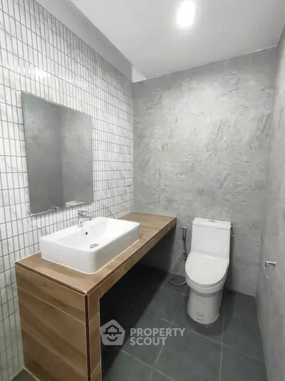 Modern minimalist bathroom with sleek fixtures and neutral tones.