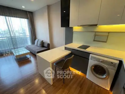 Modern open-layout living room with kitchen, featuring sleek furniture and city view.
