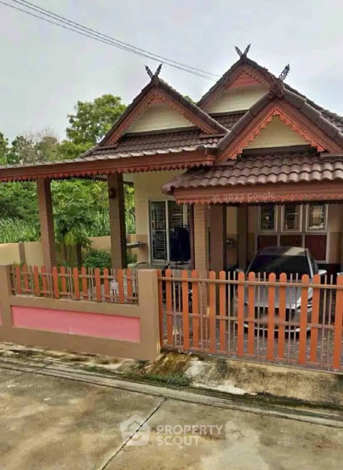 Charming traditional-style house with carport and decorative roof accents.