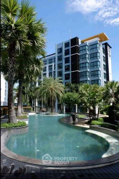 Luxurious condominium with stunning pool and lush tropical landscaping.