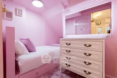 Charming pink bedroom with elegant dresser and cozy bed, perfect for a stylish and comfortable living space.