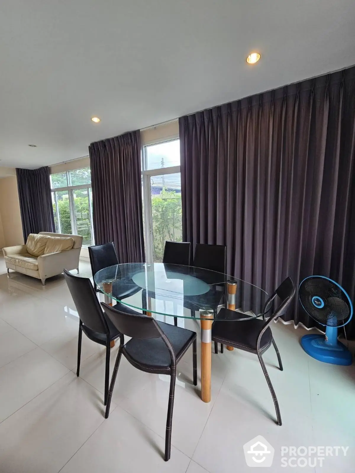 Spacious dining area with glass table and modern chairs in a bright living room