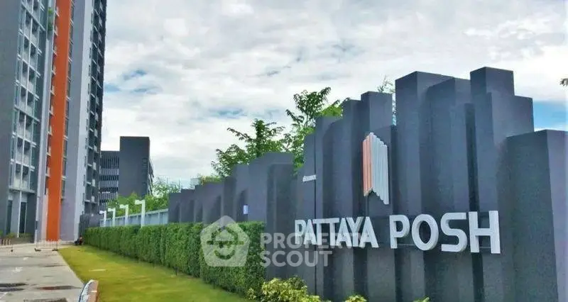 Modern high-rise building with lush greenery at Pattaya Posh entrance
