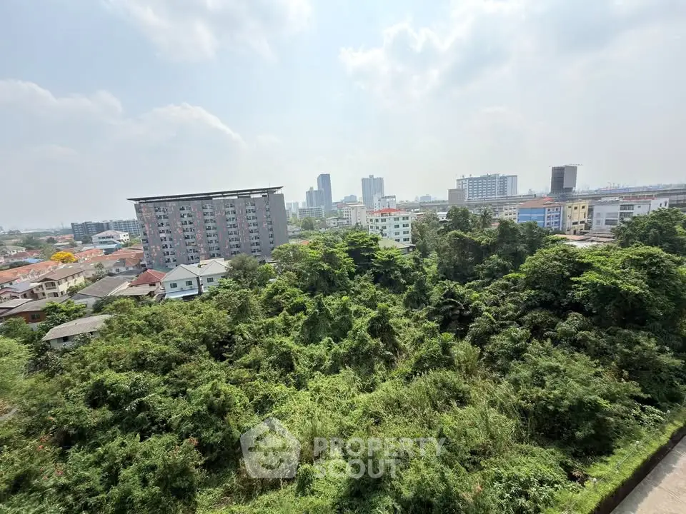 Stunning cityscape view with lush greenery and modern buildings under a bright sky.