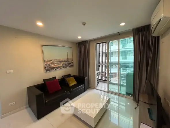 Modern living room with sleek furniture and large windows in a high-rise apartment.