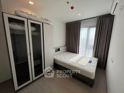 Modern bedroom with large window and stylish wardrobe in a bright apartment.
