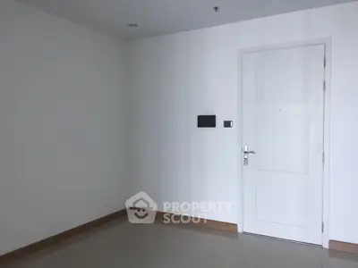 Minimalist interior with white door and sleek floor tiles in modern apartment.