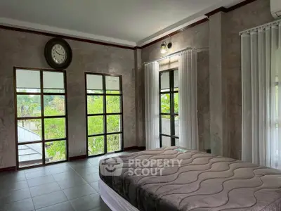 Spacious bedroom with large windows and modern decor