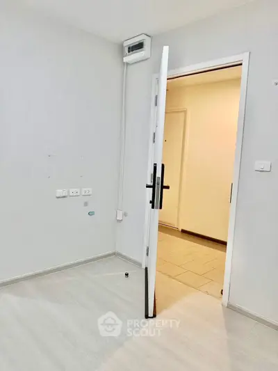 Minimalist interior room with open door and light wood flooring