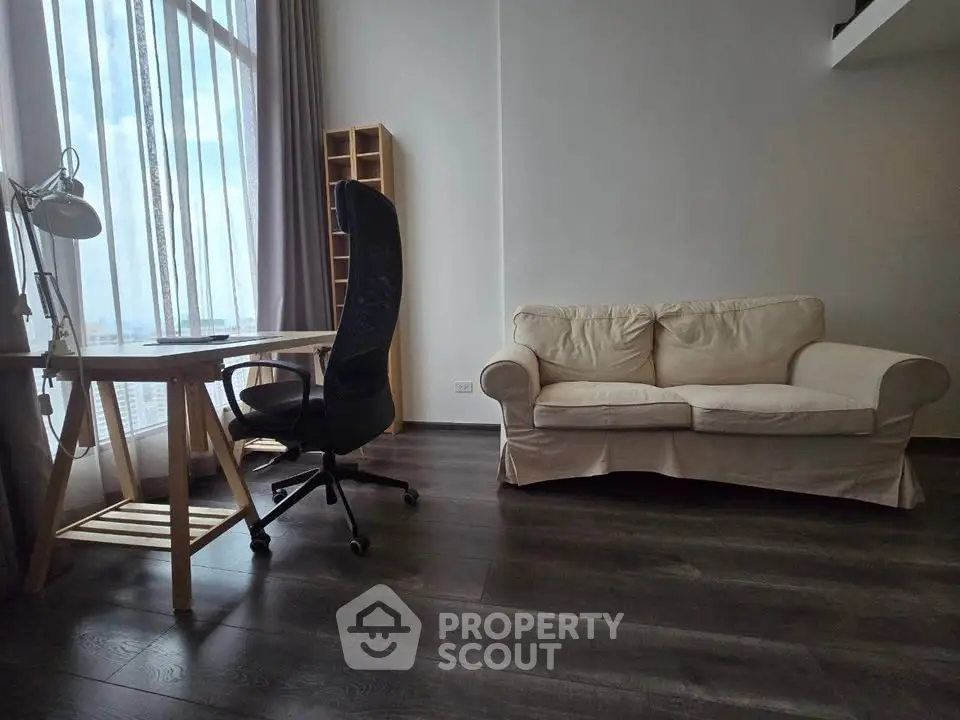 Modern living room with cozy sofa and stylish desk by large window