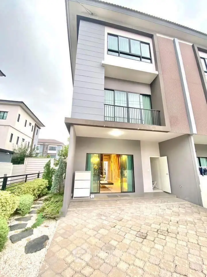 Modern townhouse exterior with large windows and small garden area