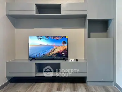 Modern living room with sleek grey entertainment unit and flat-screen TV