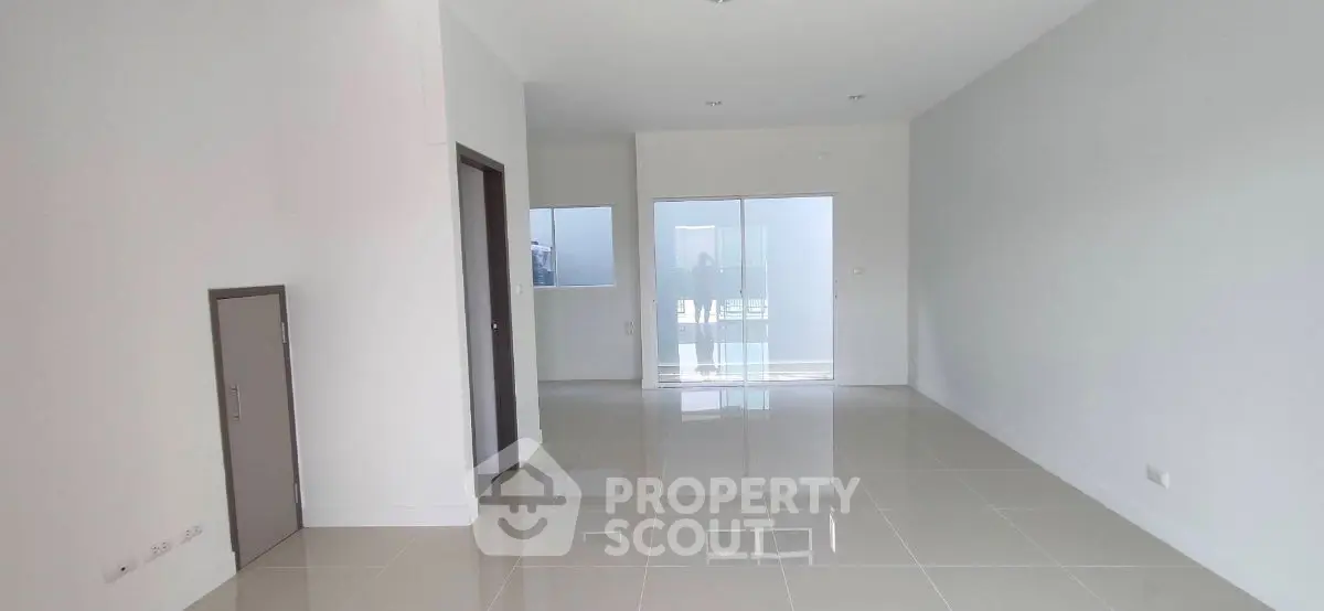 Spacious modern living room with glossy tiled floors and large windows for natural light.
