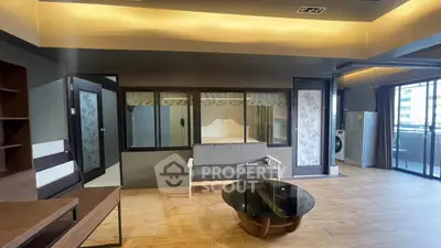 Spacious modern living room with balcony and washing machine, featuring elegant decor and ample natural light.