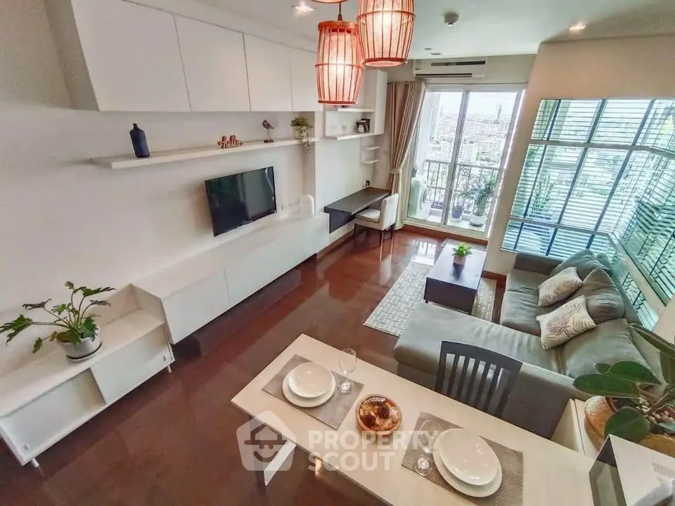 Modern living room with city view, stylish decor, and open layout in high-rise apartment.