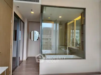 Modern bathroom with glass wall and city view, featuring a sleek bathtub and contemporary design.