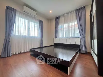 Spacious bedroom with modern bed frame and large windows for natural light