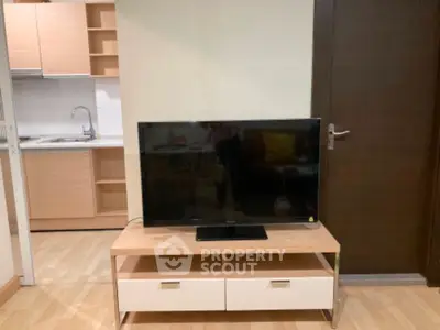 Modern living room with sleek TV stand and open kitchen layout