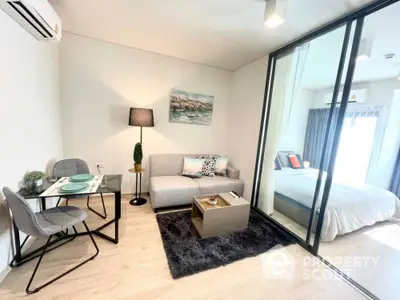 Modern studio apartment with seamless living and sleeping areas, featuring sleek furniture, a plush rug, and ample natural light.