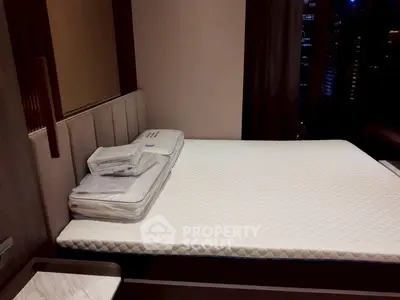 Modern bedroom with sleek design and city view, featuring a comfortable bed and stylish decor.