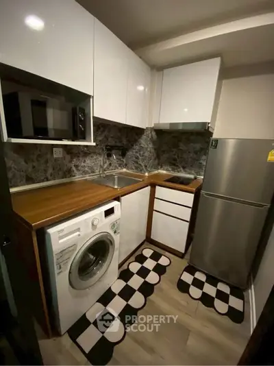 Compact modern kitchen with washing machine and sleek appliances
