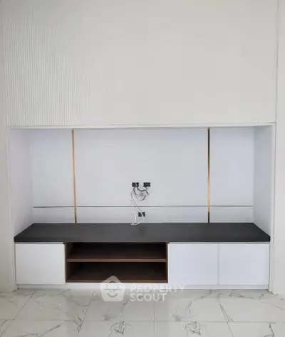 Modern minimalist built-in entertainment unit with sleek design and marble flooring