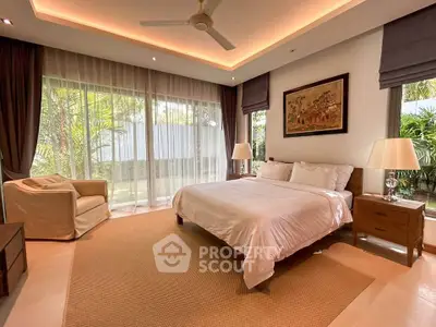Luxurious bedroom with garden view, featuring elegant decor and ample natural light, perfect for relaxation.