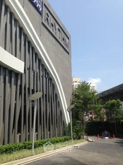Modern building exterior with unique architectural design and lush greenery.