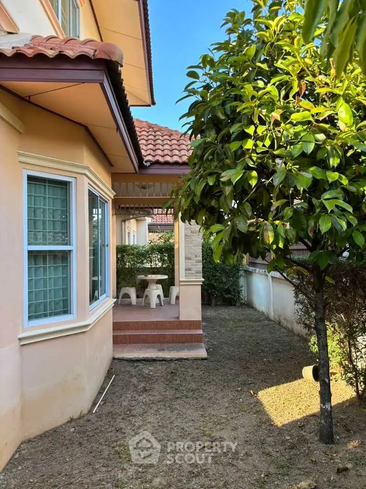 Charming suburban home with lush garden and cozy patio seating area.
