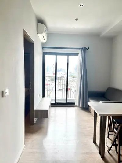 Modern living room with city view, featuring sleek furniture and large windows for natural light.