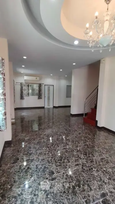 Spacious living room with elegant marble flooring and chandelier, perfect for luxury living.