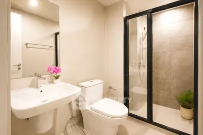 Modern bathroom with sleek design, featuring a glass shower enclosure and elegant fixtures.