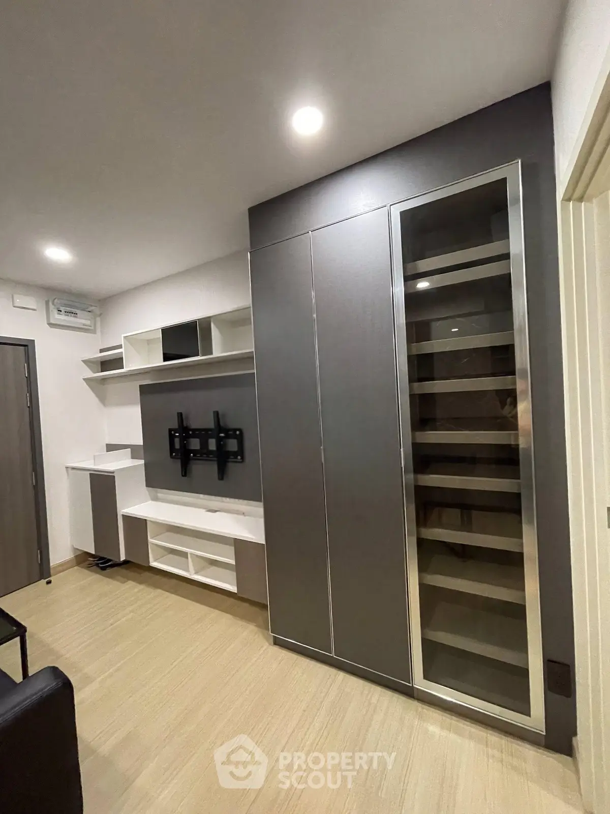 Modern living room with sleek built-in storage and TV mount, showcasing contemporary design and functionality.