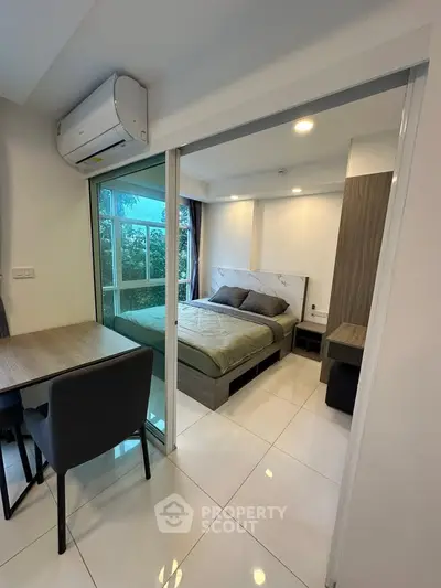Modern bedroom with glass sliding doors and stylish furnishings in a cozy apartment.