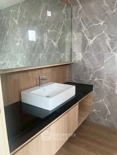 Modern bathroom with elegant marble walls and sleek vanity sink.