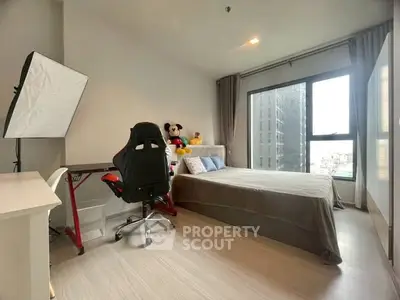 Modern bedroom with city view, featuring a cozy bed and stylish workspace.