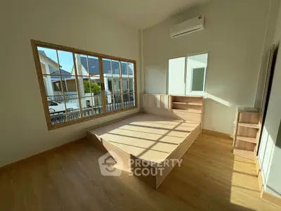 Spacious bedroom with large window and wooden flooring, featuring built-in bed and modern air conditioning.