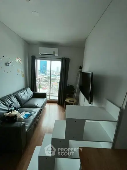 Modern living room with city view, featuring sleek furniture and natural light.