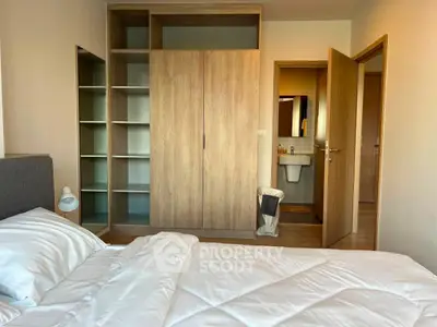 Spacious bedroom with modern wooden wardrobe and cozy bed setup