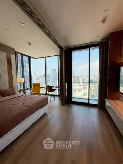 Luxurious bedroom with stunning city view and modern furnishings in high-rise apartment.