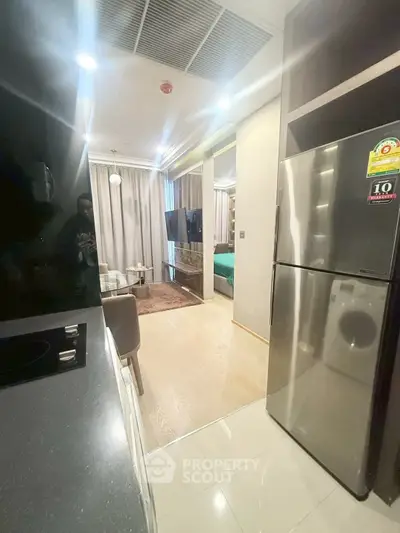 Modern open-layout kitchen with sleek appliances and cozy living area in a stylish apartment.