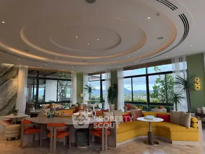 Luxurious living room with panoramic windows and elegant decor, offering stunning views and modern furnishings.