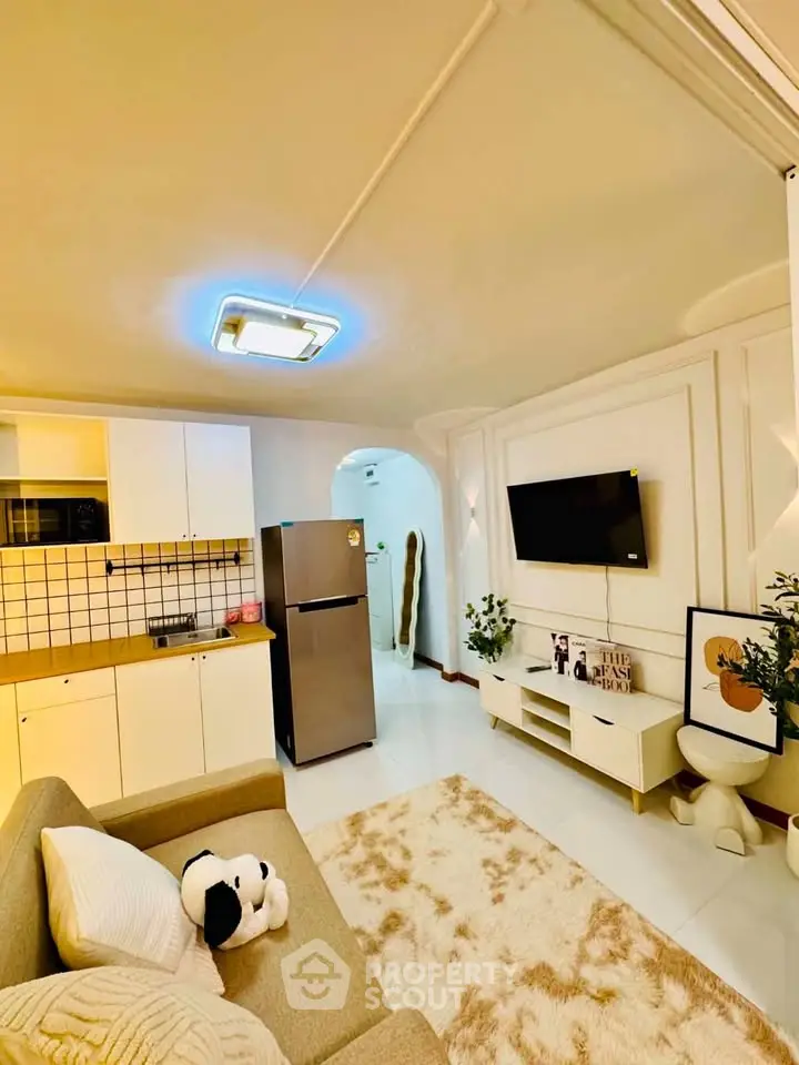 Charming living room with modern decor, cozy sofa, and sleek kitchen area, perfect for urban living.