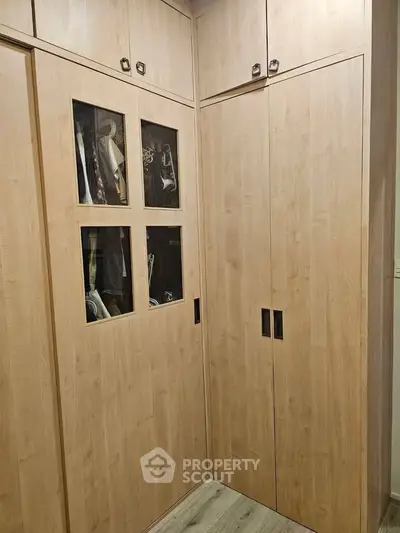 Spacious walk-in closet with wooden cabinetry and ample storage space.