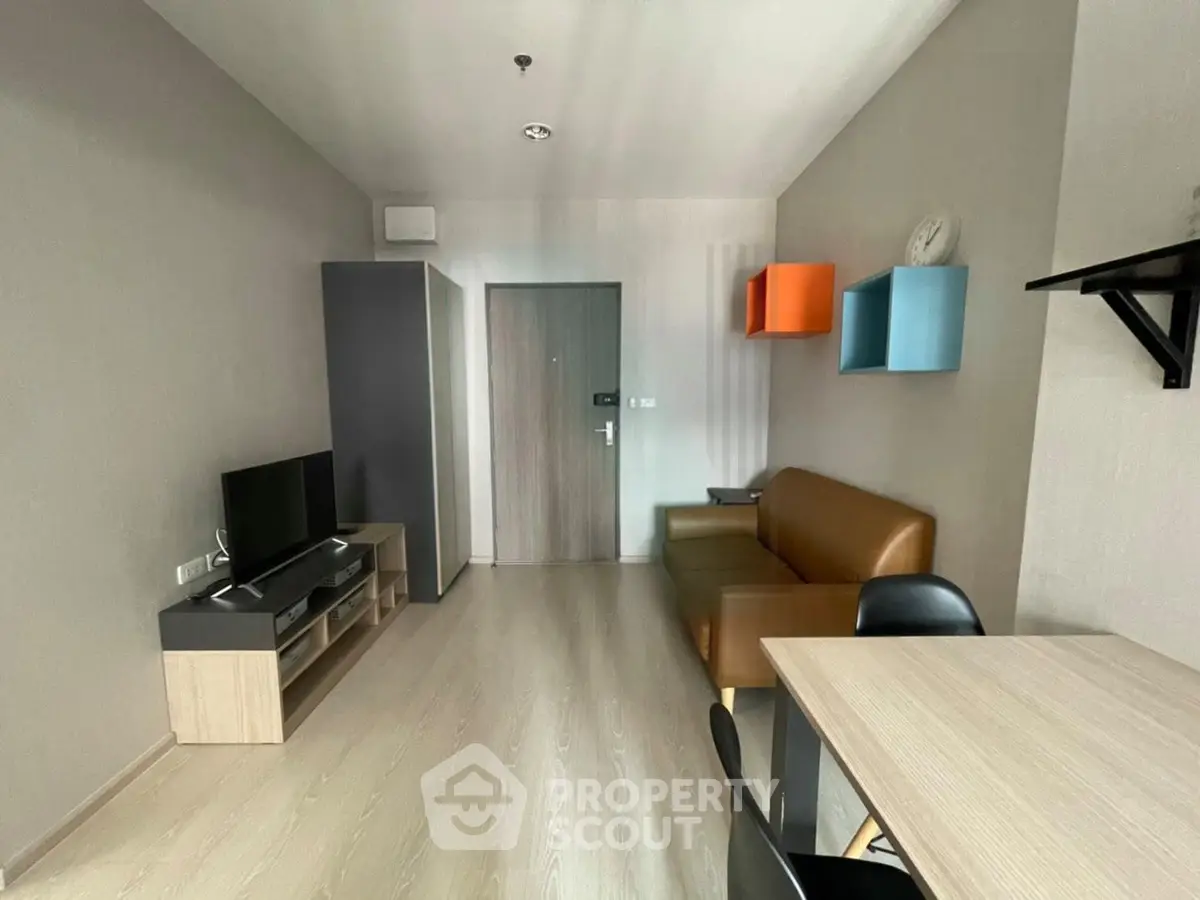 Modern living room with sleek furniture and wall-mounted shelves in a cozy apartment.